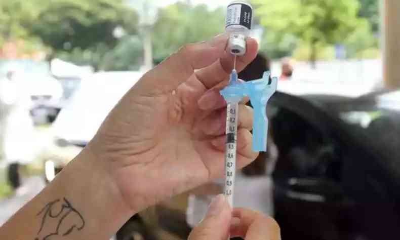 Uma seringa sendo segurada para aplicao de uma vacina