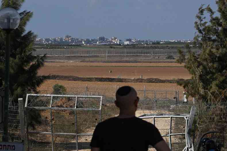 Homem no Kibutz de Beeri observa Gaza