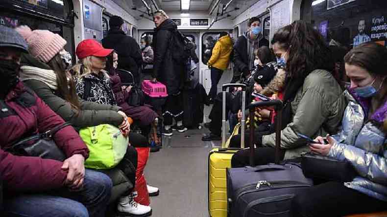 Pessoas carregam malas e outros pertences no metr de Kiev na manh de 24 de fevereiro