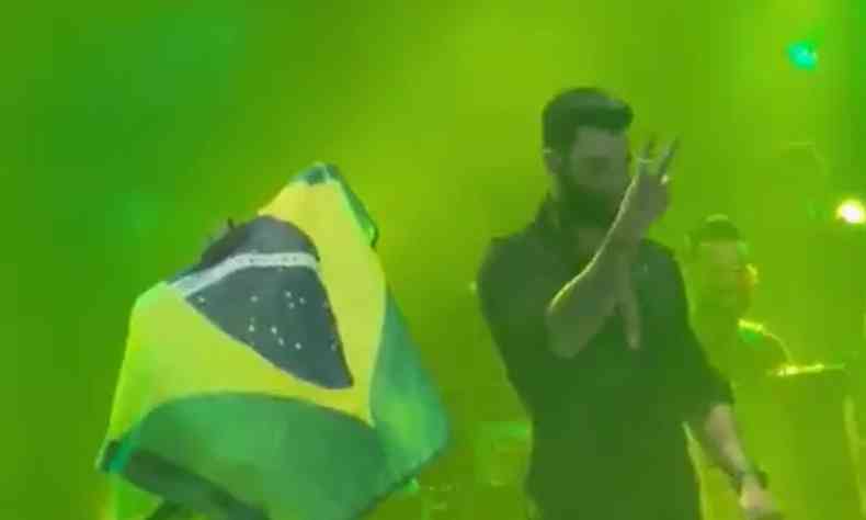 Gusttavo Lima fazendo gesto de 22 com as maos durante o show