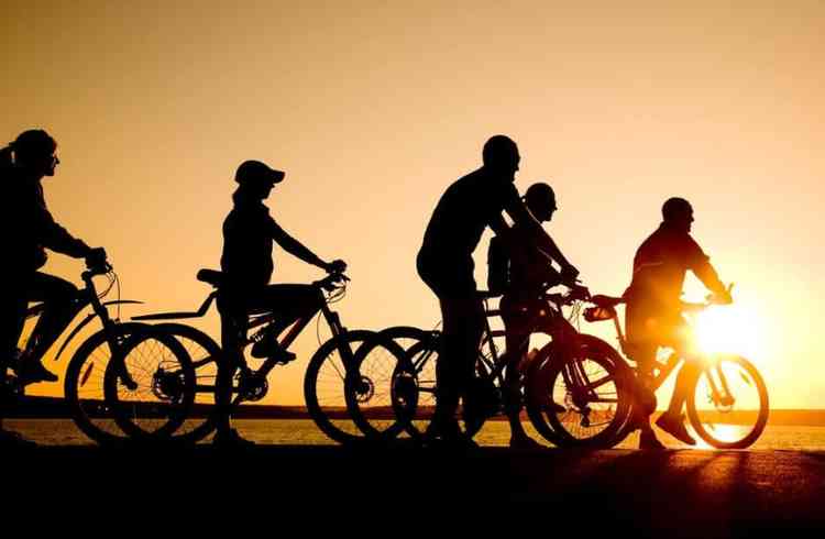 Ciclistas andando de bicicleta no pr do sol