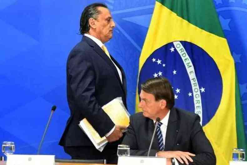Jair Bolsonaro em primeiro plano, com seu advogado Frederick Wassef caminhando ao fundo