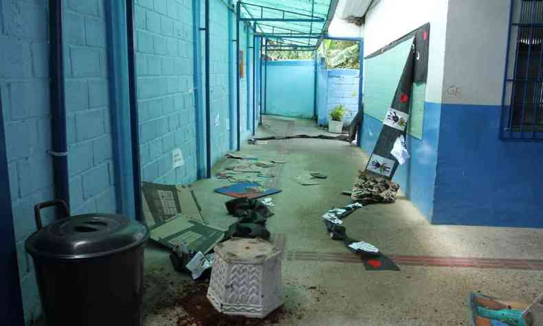 Na foto, corredor da Escola Municipal Jos Diniz, com cadeiras quebradas, vasos de plantas revirados e pichaes