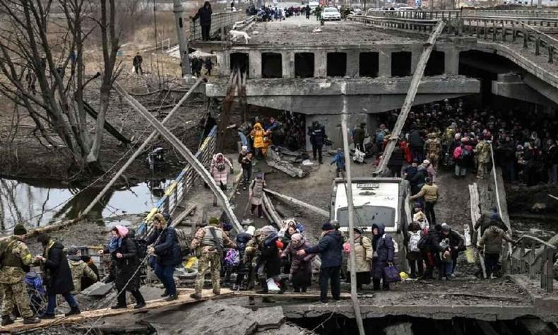 Pessoas atravessam uma ponte destruda ao evacuar a cidade de Irpin, 5 de maro de 2022