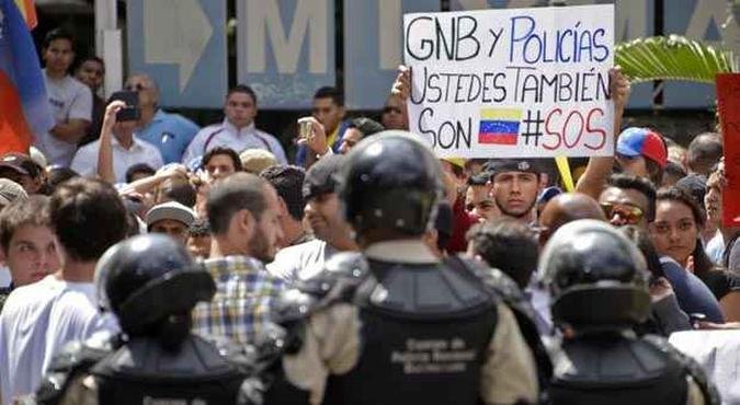 Manifestante anti-governo pede apoio � Guarda Nacional Bolivariana e pol�cias(foto: JUAN BARRETO / AFP)