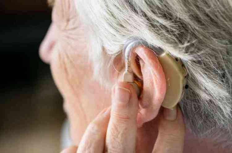 Mulher idosa com aparelho auditivo