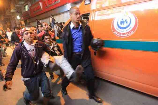 Manifestantes resgatam ferido durante ao da polcia contra protesto no Cairo(foto: AFP PHOTO/KHALED DESOUKI )