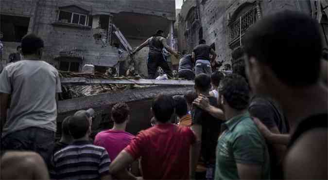 Palestinos procuram por vtimas de ataque israelense no campo de refugiados de al-Shati, em Gaza(foto: AFP PHOTO/MARCO LONGARI )