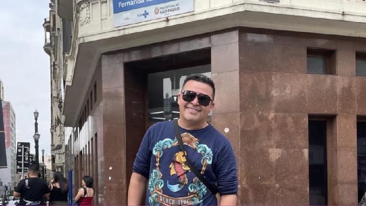 Daniel Araujo posando para a foto e sorrindo em frente a posto de sade