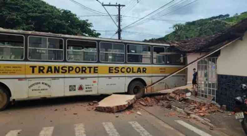 nibus escolar com a frente dentro de uma construo com destroos espalhados no cho