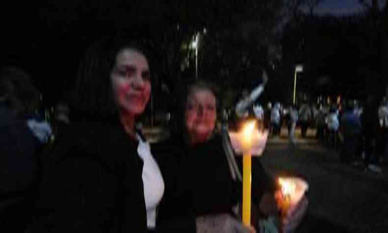 Rose Sousa e a mãe, Maria Lara, seguram velas na procissão 