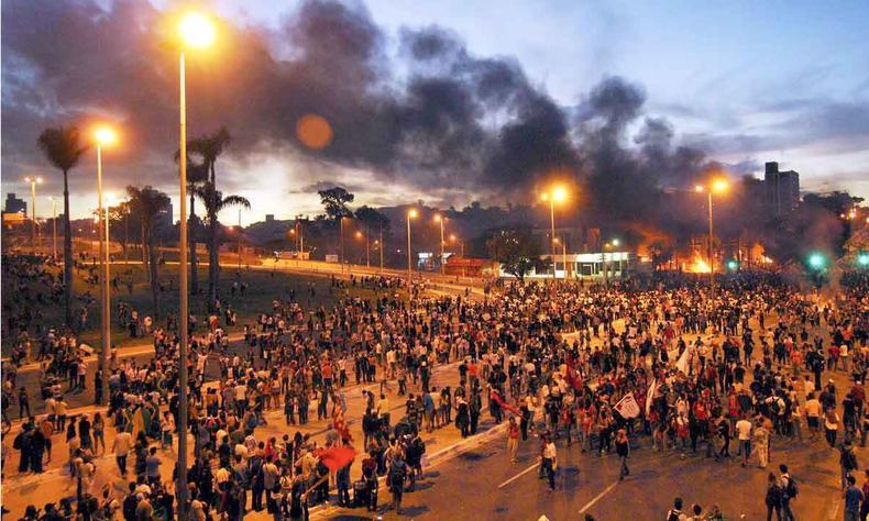 Com fumaa preta ao fundo, centenas de pessoas so vistas ao redor do estdio do Mineiro, durante protesto, em junho de 2013