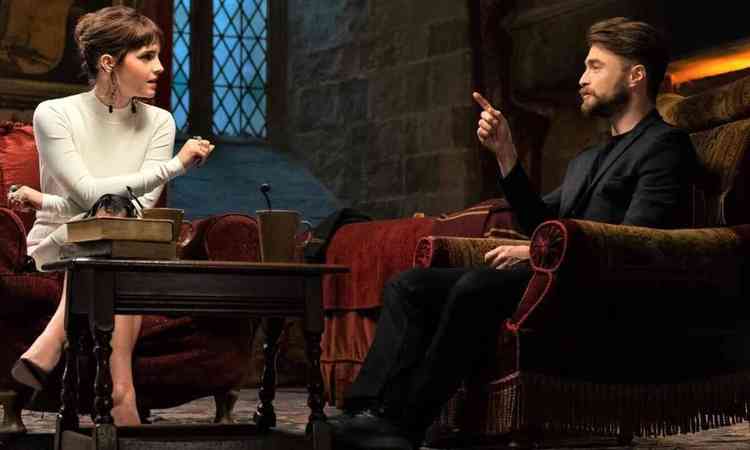 Sentados em poltronas em cenrio que lembra a escola de Harry Potter, os atores Emma Watson e Daniel Radcliffe conversam