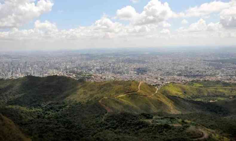 Vista mostra pico da Serra do Curral, com vegetao em destaque no primeiro plano e prdios no fundo da paisagem