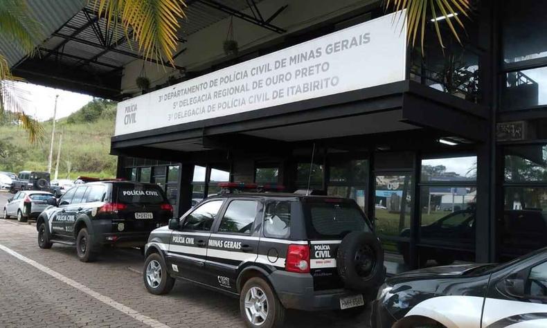 Fachada da delegacia em Ouro Preto vista de perfil. Trs carros estacionados na porta da delegacia. 