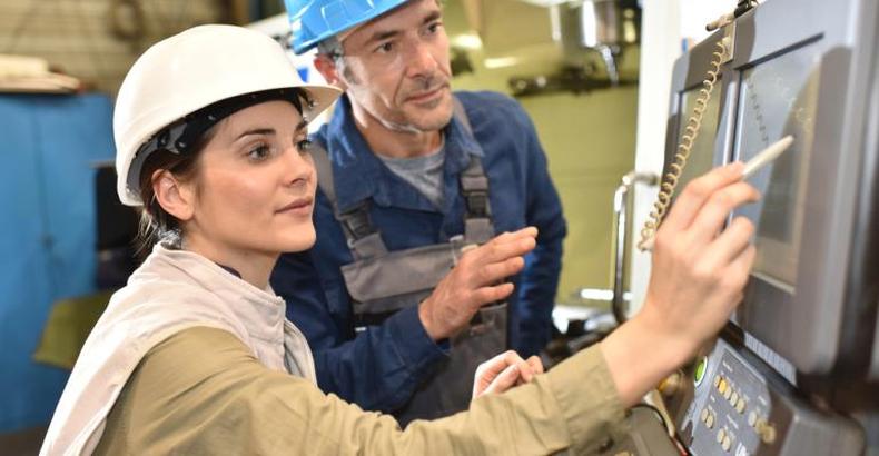 Mulher e homem em trabalho de aprendizagem industrial