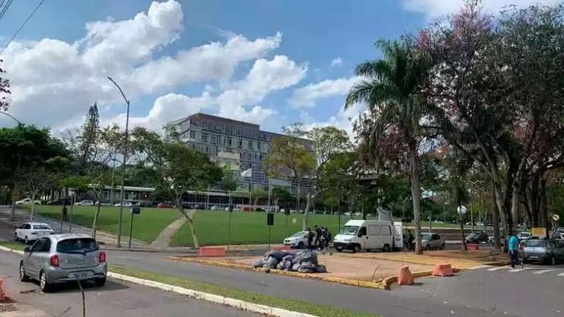 Campus de uma universidade com um carro passando em uma das ruas 