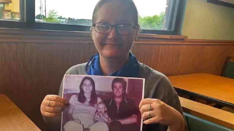 Holly Crouse segura uma foto dos pais assassinados