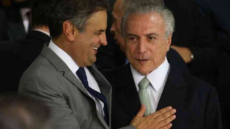 Aécio Neves e Michel Temer se cumprimentam; Aécio sorri