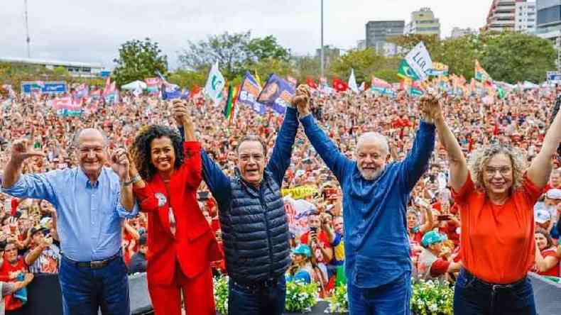 Polticos posam com multido no fundo