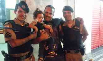 Maria Eduarda j no colo do pai, Fabiano Marrano, acompanhado dos policiais: susto e emoo(foto: Polcia Militar/Divulgao )
