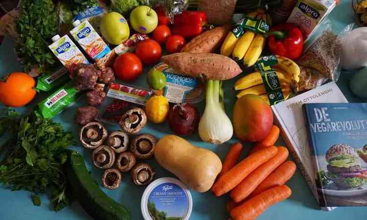 bancada com vegetais, frutas, verduras, legumes e produtos de origem vegetal, como leite