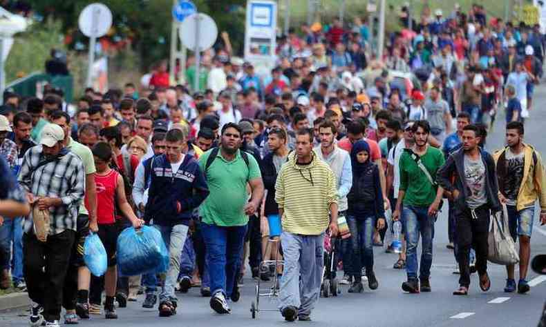 Grupo de cerca de 500 imigrantes caminham entre a fronteira da Hungria com a ustria(foto: ATTILA KISBENEDEK / AFP)