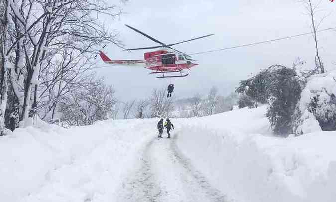 Helicptero dos bombeiros sobrevoa regio do hotel atingido pela avalanche no centro da Itlia(foto: Guardia di Finanza/Divulgao )