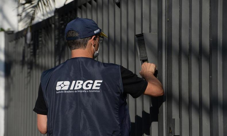 homem com a jaqueta do ibge tocando o interfone 