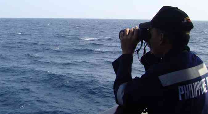 Membro da guarda costeira das Filipinas participa das buscas pela aeronave desaparecida (foto: AFP PHOTO /Philippine Navy)