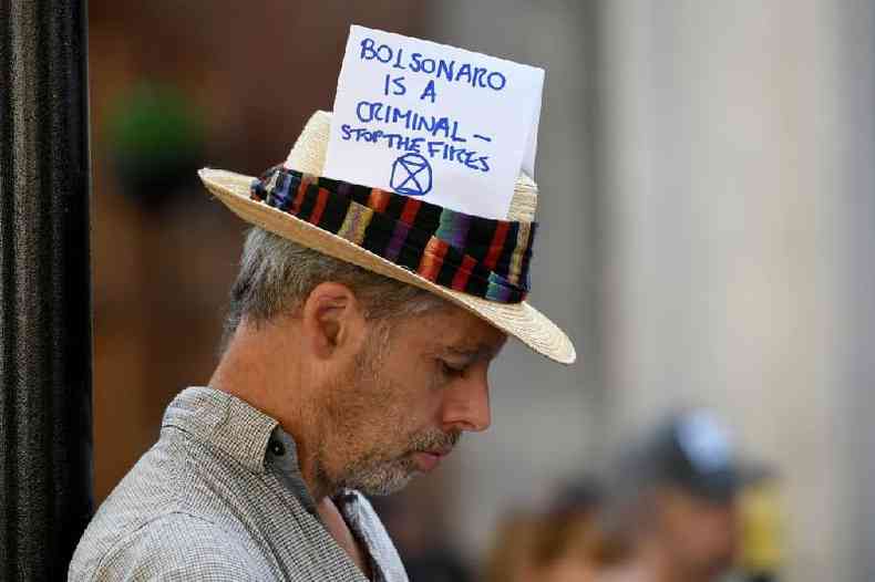 'Bolsonaro  um criminoso %u2014 Parem os incndios', diz mensagem no chapu de ativista em protesto na Embaixada do Brasil em Londres, em 2019