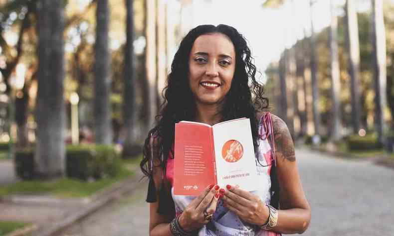 Poeta Ana Paula Dacota segura o livro A mo  uma pista de voo