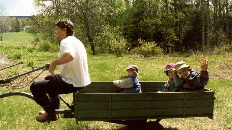 Pai com dois filhos na carroa