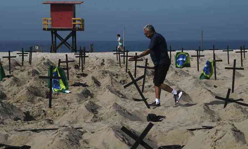Morador contrrio ao protesto derrubou uma das cruzes instaladas na praia de Copacabana em homenagem s vtimas de COVID-19 no Rio(foto: CARL DE SOUZA/AFP)