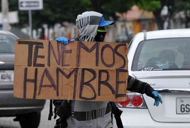 Venezuelano segura cartaz dizendo que tem fome e pede ajuda nas ruas de Guayaquil, no Equador(foto: Jose Sanchez/AFP)