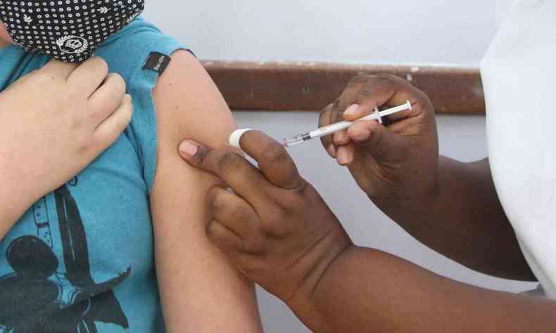 detalhe de criana sendo vacinada em BH