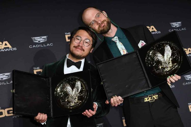 Cineastas Daniel Kwan e Daniel Scheinert encostam as cabeas enquanto seguram o trofu do DGA Awards, dado ao filme Tudo em todo o lugar ao mesmo tempo