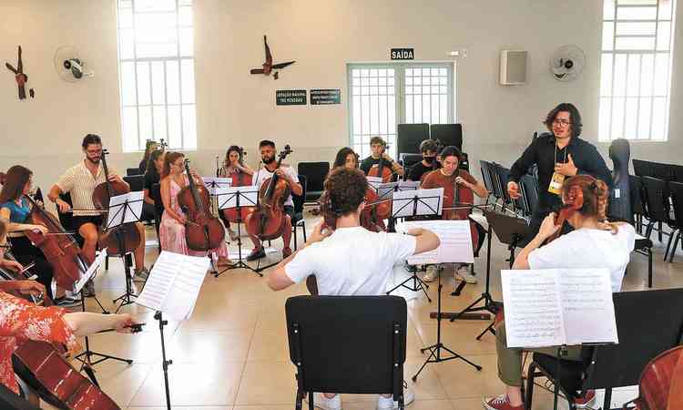 Msicos ensaiam em sala concerto de violoncelos
