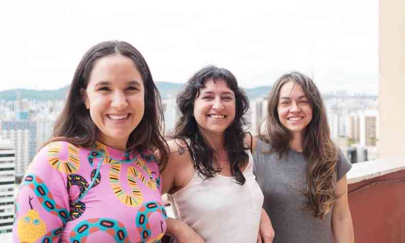 Juliana Flores, Janaina Macruz e Priscila Amoni, em p, em espao aberto, sorriem