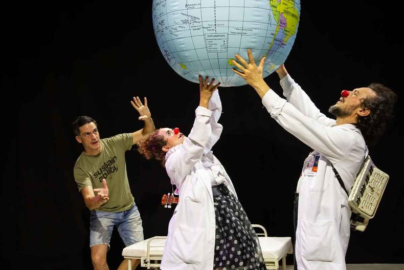 Os palhaos Dra. Xuleta e Dr. Custdio seguram no alto um globo terrestre de plstico, observados por Mateus Solano