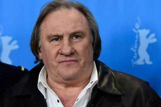 imagem do ator Grard Depardieu de roupa preta com fundo azul