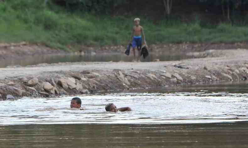 Duas crianças mergulham nas águas da barragem 