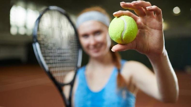 Tenista segurando bola de t�nis na quadra