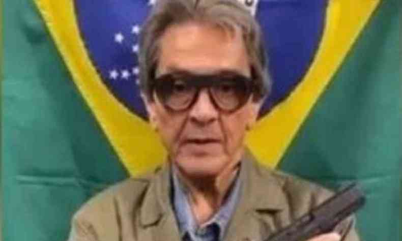 Roberto Jefferson segura arma em frente a bandeira do Brasil