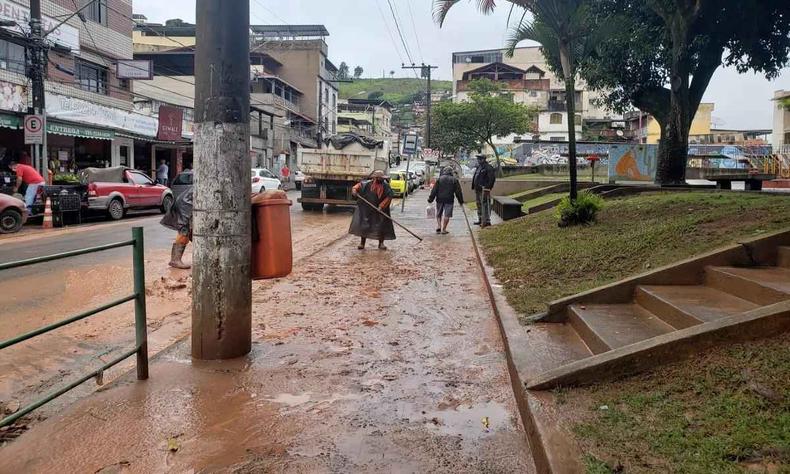 Moradores limpam calada aps a chuva 