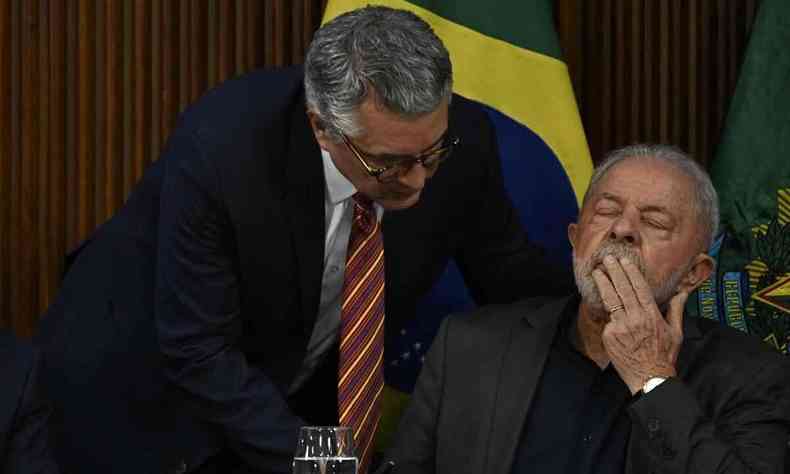 Ministro Alexandre Padilha est de p e fala com Lula, que est de olhos fechados