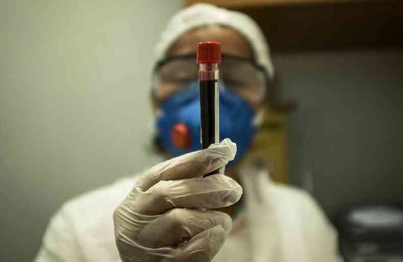 Enfermeira segura amostra de sangue tirada para teste de deteco da covid-19, na favela da Rocinha, no Rio de Janeiro, em 15 de abril de 2020. ( AFP / Florian Plaucheur)