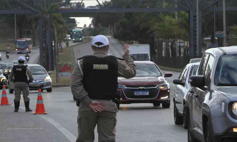 policial em blitz mandando os carros seguirem 