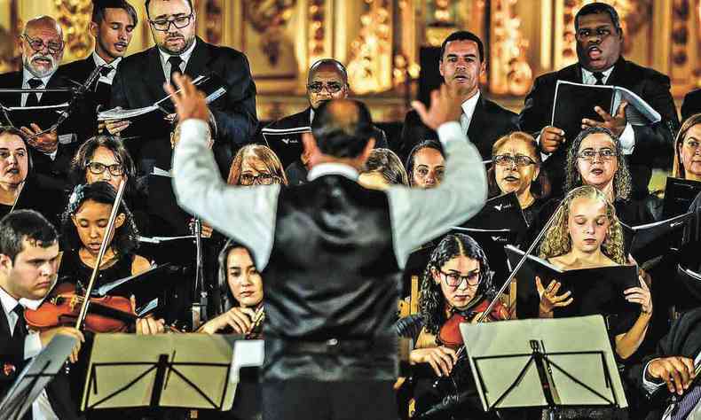 Maestro rege orquestra e coral Cidade dos Profetas em igreja 