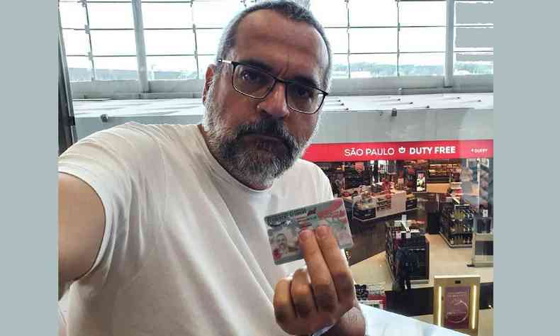 Abraham Weintraub em um aeroporto segurando um documento dos Estados Unidos nas mos
